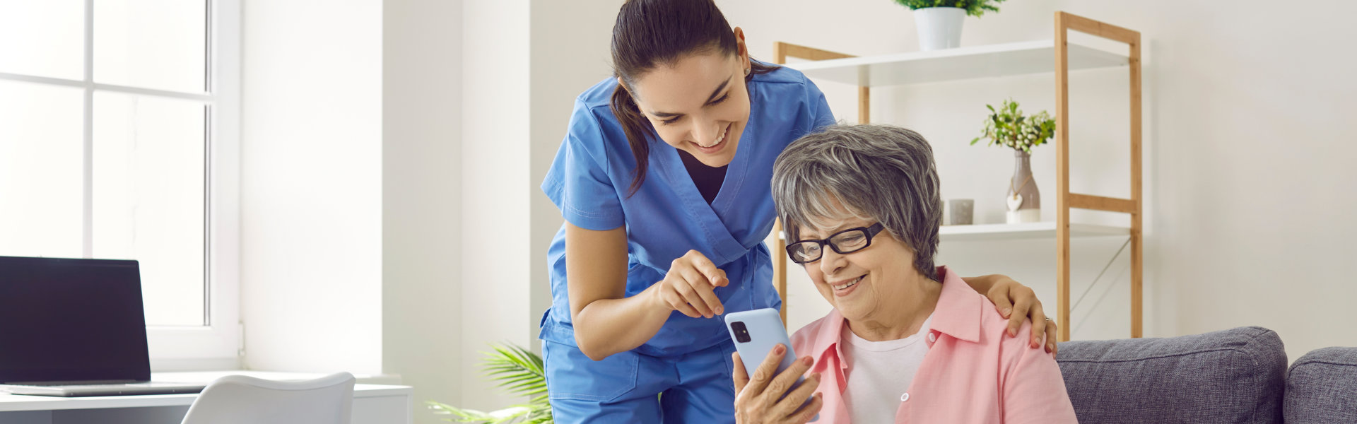 nurse and elderly woman looking at the cellphone